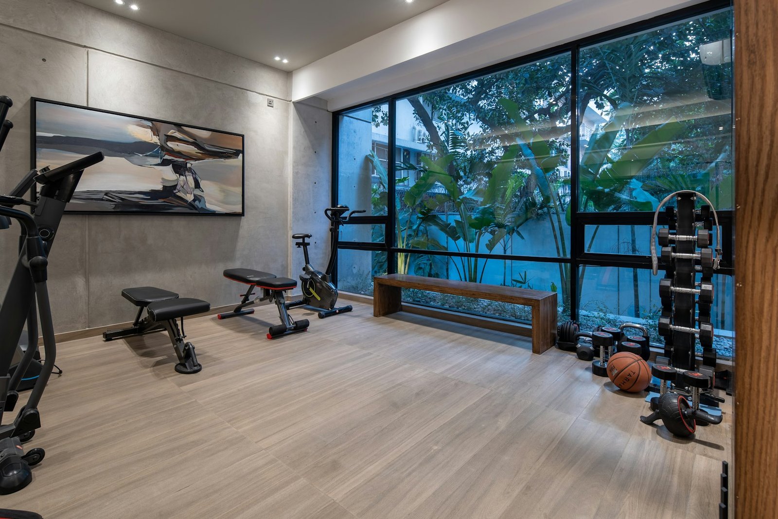 Assembled home gym with weight benches, an exercise bike and a dumbbell rack