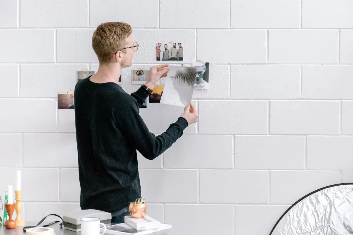 Hanging framed photos on a white brick wall